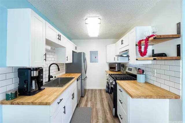 a kitchen with stainless steel appliances granite countertop a sink stove and refrigerator