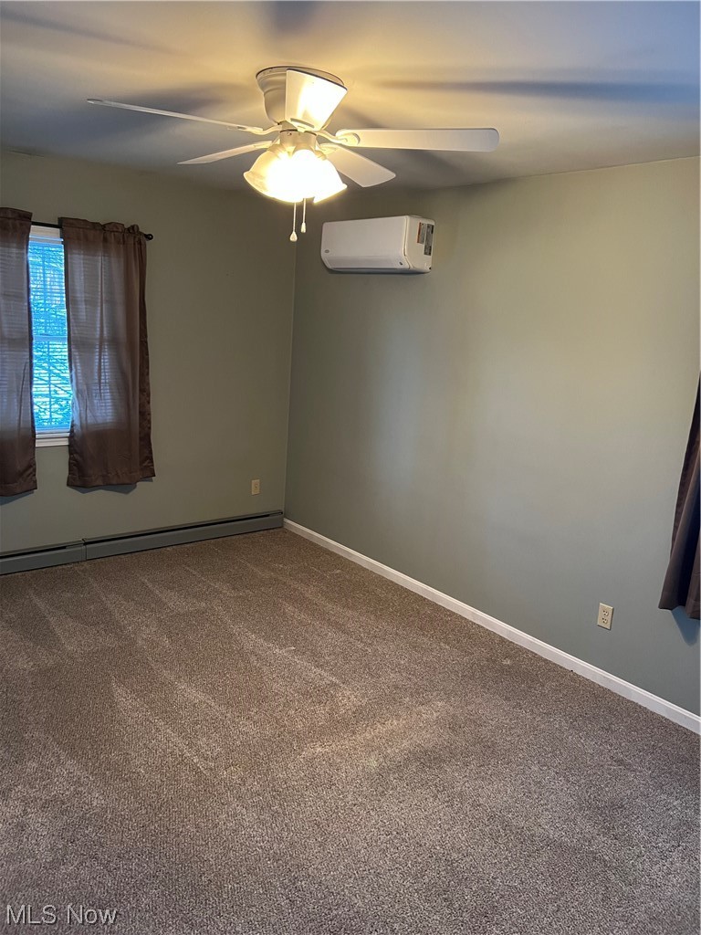 3215 Warren - Sharon Road Vienna, OH 44473 - Photo 16 of 25 Carpeted empty room with ceiling fan, a baseboard radiator, and a wall unit AC