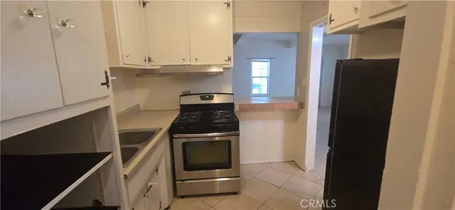 a kitchen with stainless steel appliances granite countertop a stove a refrigerator and a cabinets