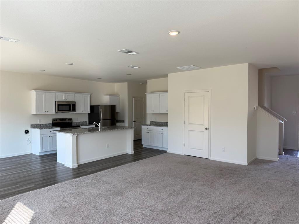 2104 Jackson Street Princeton, TX 75407 - Photo 13 of 15 a living room with stainless steel appliances kitchen island sink refrigerator and a fireplace