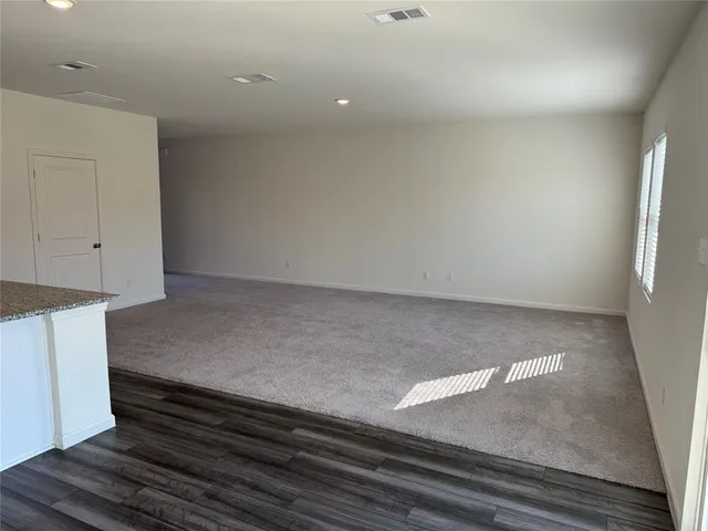 a living room with stainless steel appliances kitchen island sink refrigerator and a fireplace