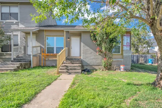 a view of a house with backyard and a tree