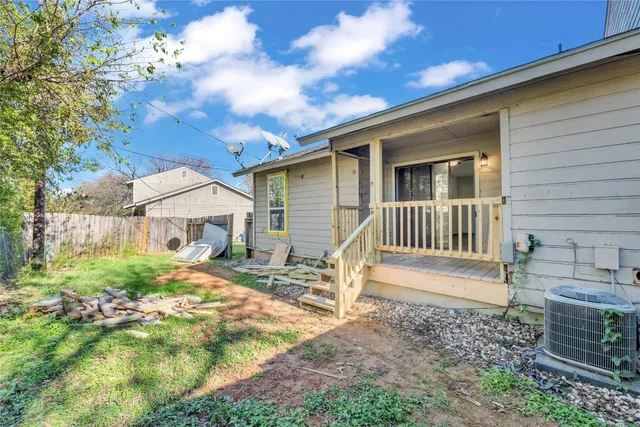 a view of a house with a yard and wooden fence