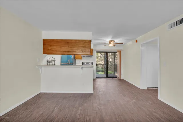 a view of a hallway with wooden floor and cabinet