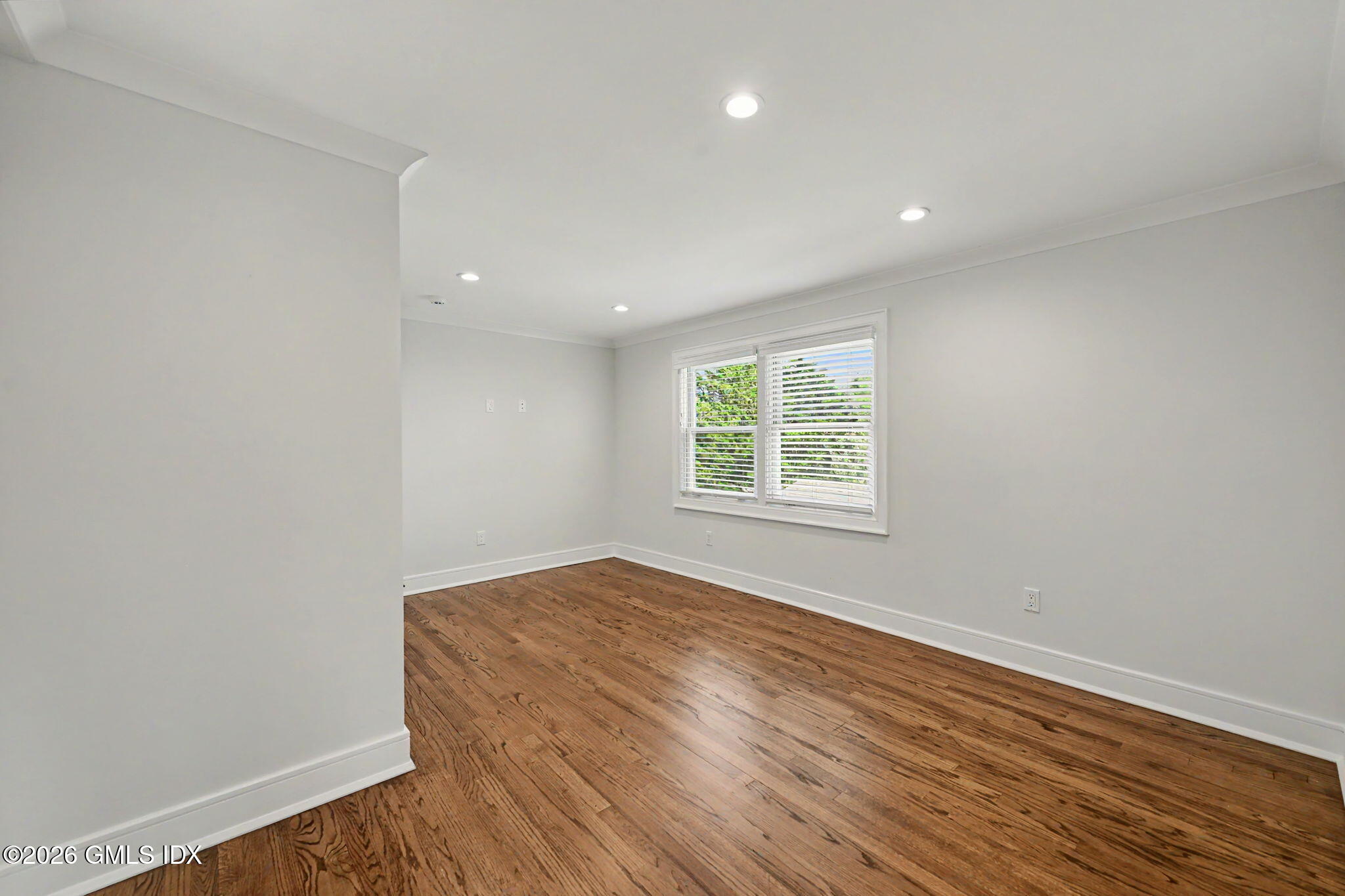 124 Shore Road Old Greenwich, CT 06870 - Photo 18 of 28 an empty room with wooden floor and windows