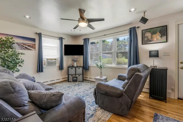 a living room with furniture a large window and a flat screen tv