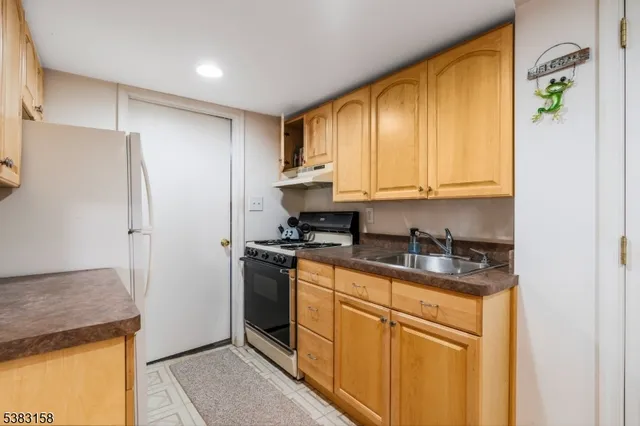 a kitchen with stainless steel appliances granite countertop a refrigerator and a stove