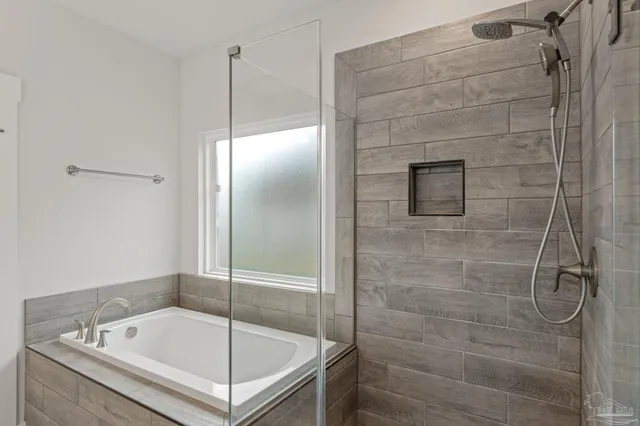 a bathroom with a tub shower and sink