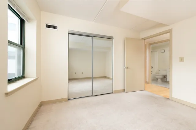an empty room with a bathroom and a glass door