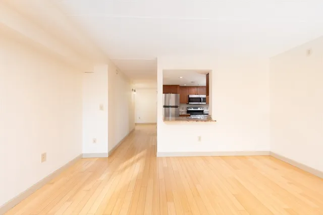 a view of kitchen and hall with wooden floor