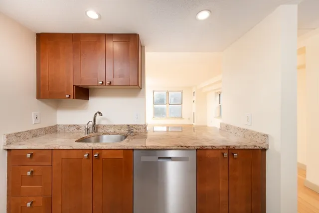 a kitchen with granite countertop a sink a stove cabinets and counter space