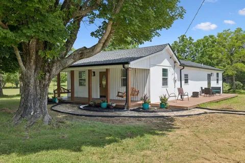 a view of a house with backyard sitting area and garden