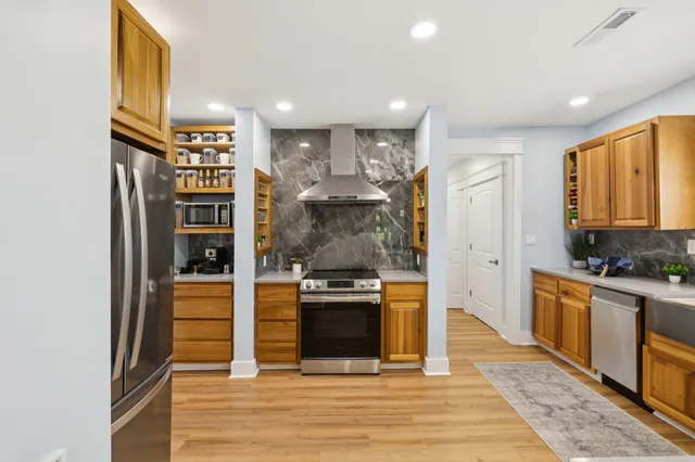 a kitchen with granite countertop a refrigerator stove and wooden floor