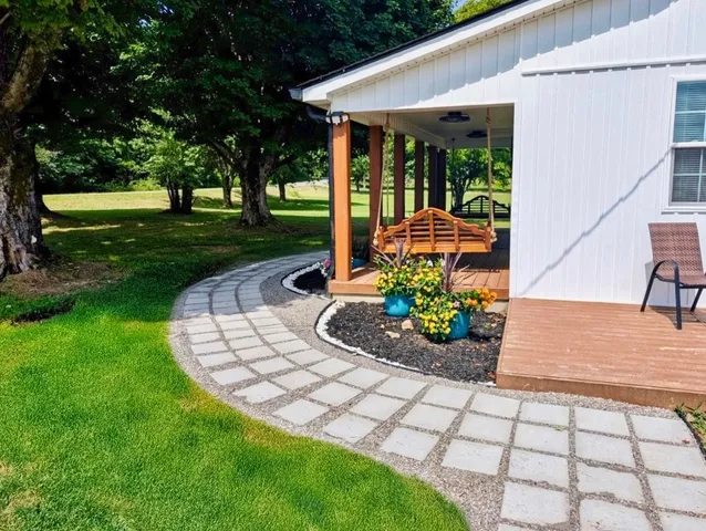 a view of a house with a big yard and large trees