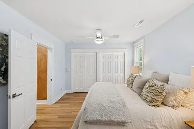 a view of empty room with wooden floor and fan