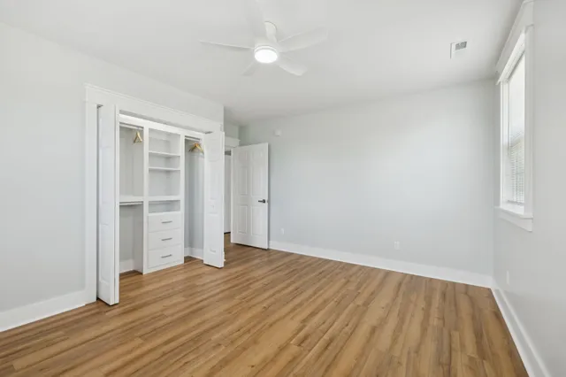 a view of a room with wooden floor and windows