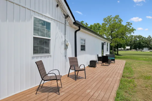 an aerial view of residential houses with outdoor space and trees