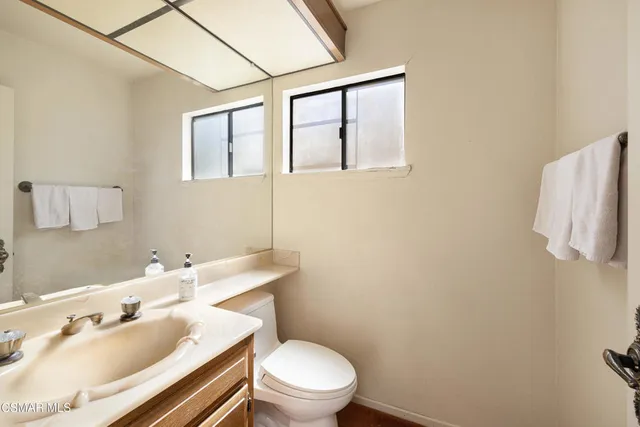 a bathroom with a sink mirror vanity and toilet