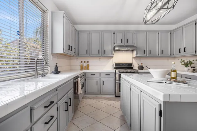 a kitchen with white cabinets and appliances