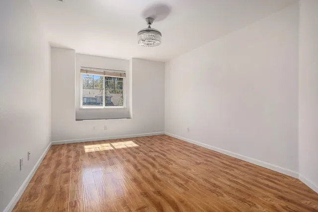 a view of a room with wooden floor and a window