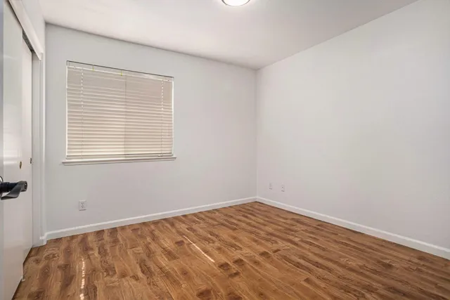 a view of empty room with wooden floor
