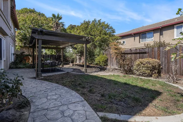 a view of a patio with table and chairs potted plants with floor to ceiling window