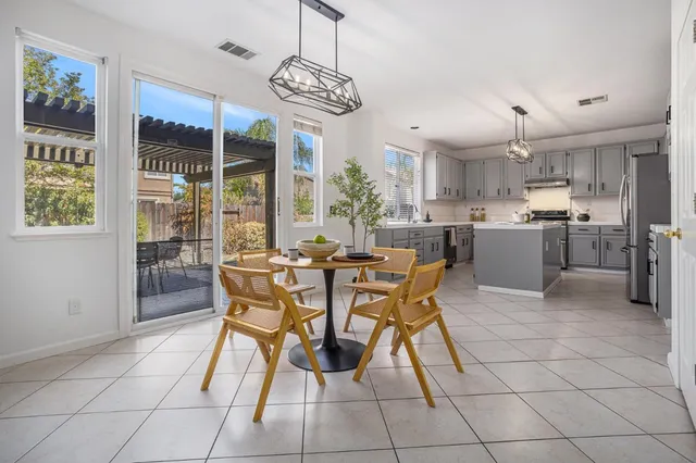 a dining room with furniture a chandelier and a flat screen tv
