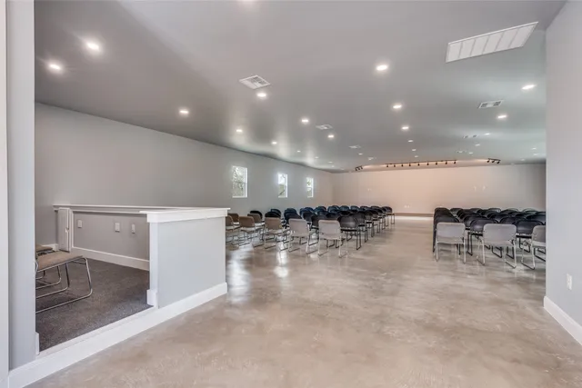 a view of a room with lots of chairs and wooden floor