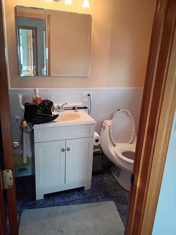 a bathroom with a toilet a sink and a mirror