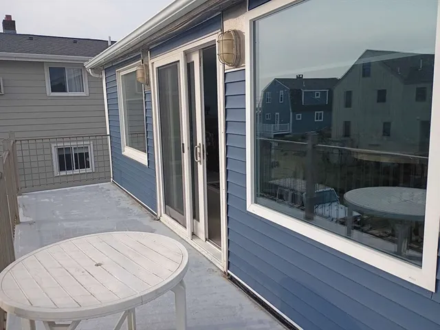 a view of a balcony with a dining table and chairs