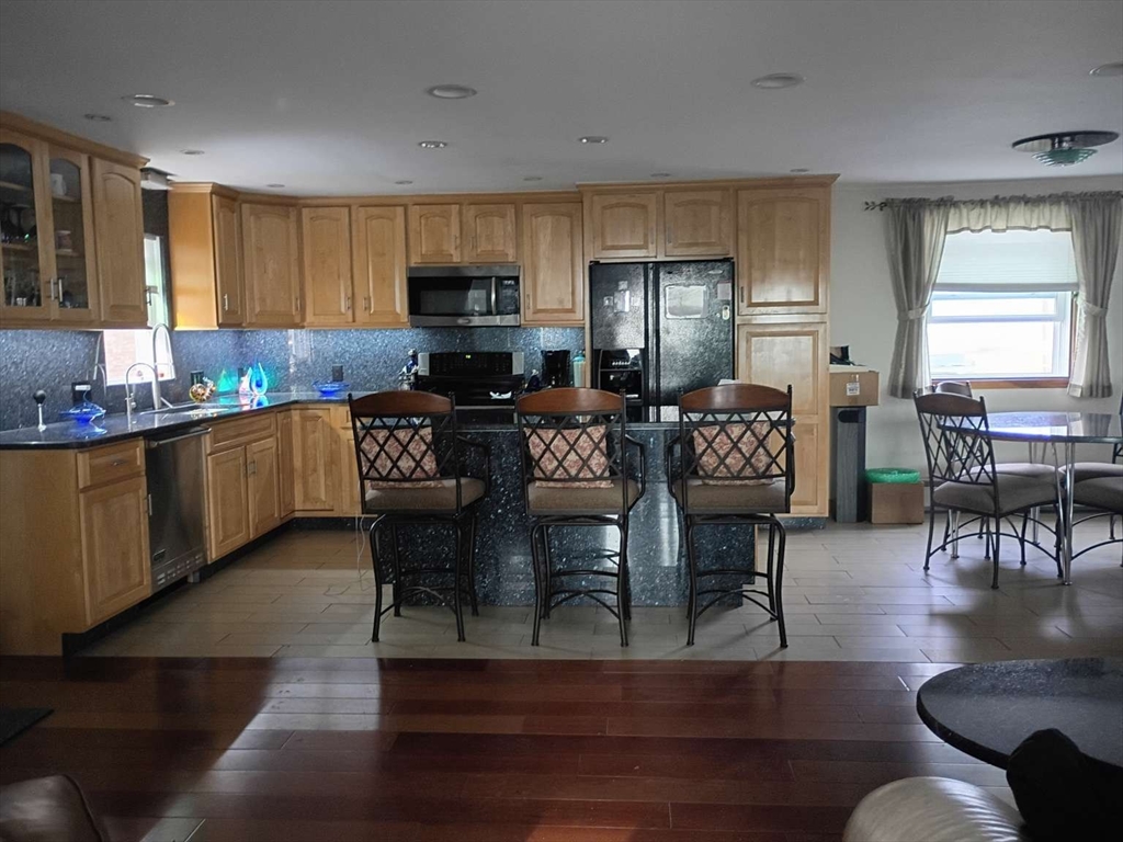 6 Tilden Avenue Scituate, MA 02066 - Photo 6 of 34 a kitchen with stainless steel appliances granite countertop a living room dining table and chairs