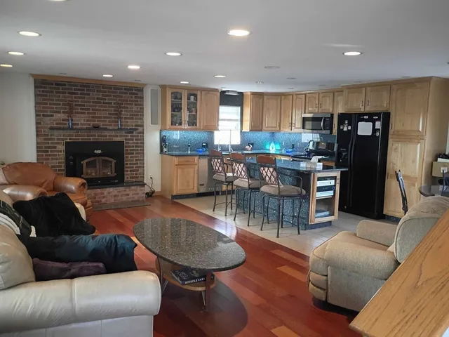 a living room with furniture a fireplace and kitchen view