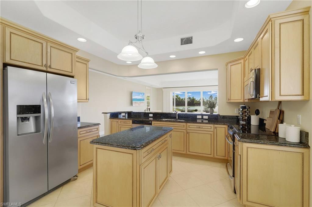 19741 Marino Lake Circle, Unit 802 Miromar Lakes, FL 33913 - Photo 11 of 38 a kitchen with stainless steel appliances granite countertop a sink a stove a refrigerator and island