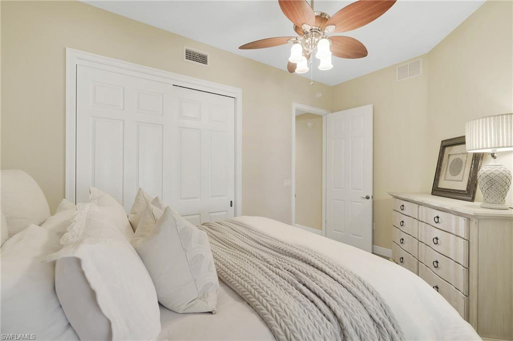 19741 Marino Lake Circle, Unit 802 Miromar Lakes, FL 33913 - Photo 16 of 38 a bedroom with a bed and a chandelier