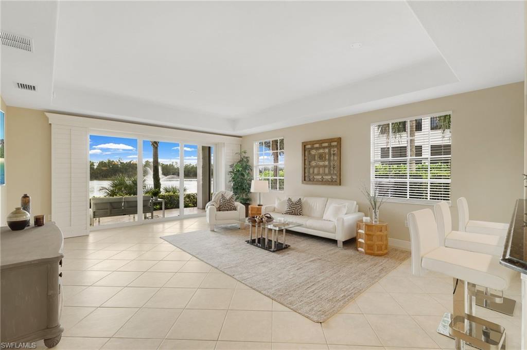19741 Marino Lake Circle, Unit 802 Miromar Lakes, FL 33913 - Photo 3 of 38 a living room with furniture and large windows