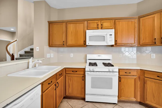 a kitchen with cabinets appliances a sink and a counter top space