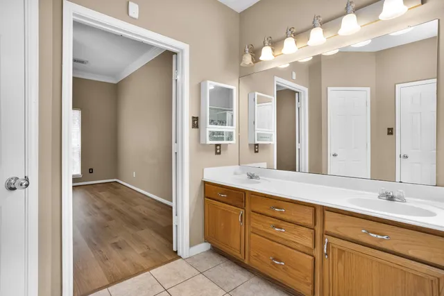 a spacious bathroom with a granite countertop sink a mirror and a shower