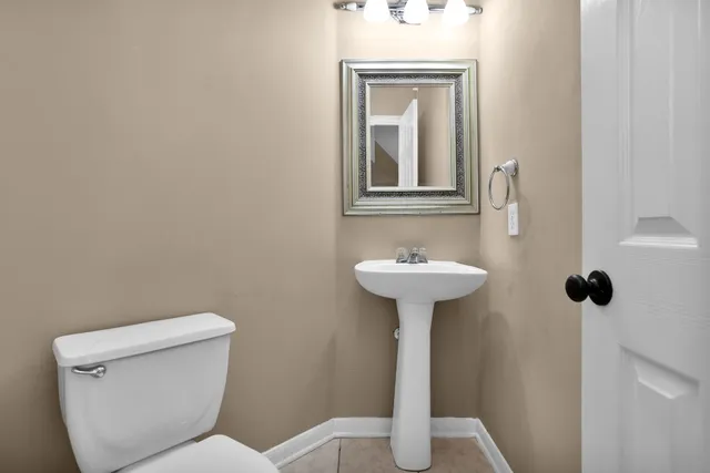 a bathroom with a toilet sink and mirror