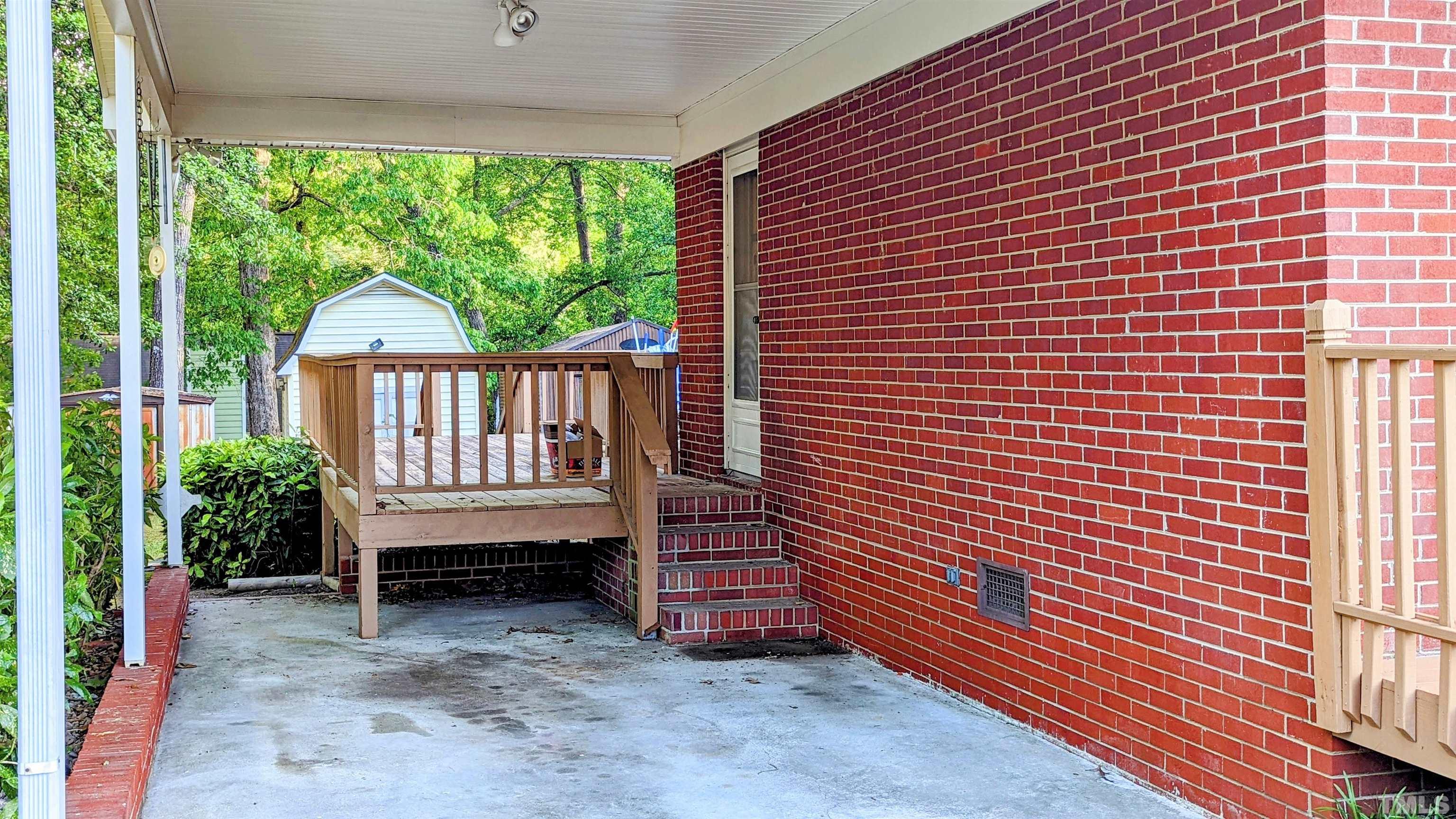 4901 Vallery Place Raleigh, NC 27604 - Photo 2 of 22 a view of a deck with a table and chairs next to a yard