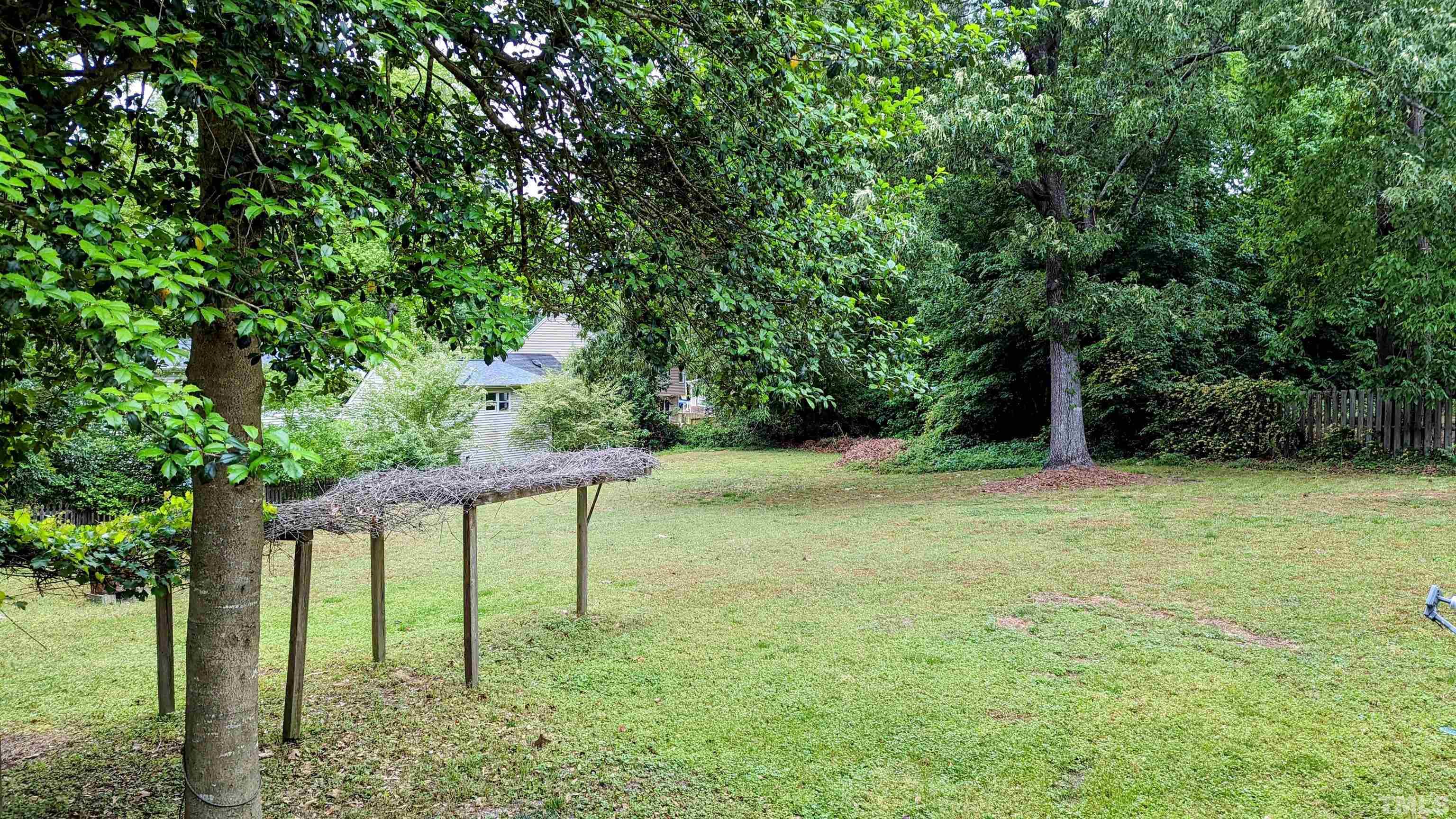 4901 Vallery Place Raleigh, NC 27604 - Photo 22 of 22 a backyard of a house with large trees and plants