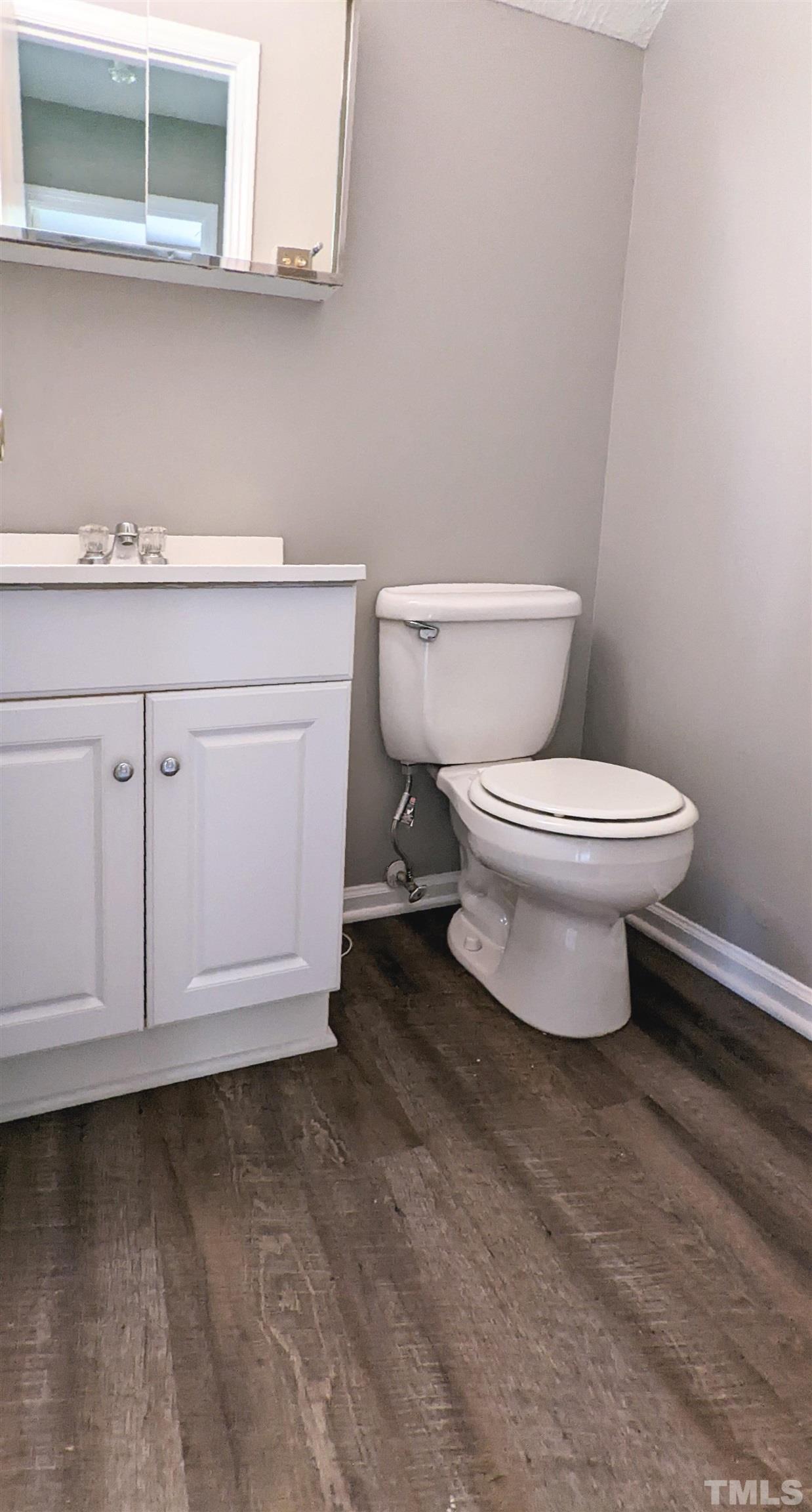 4901 Vallery Place Raleigh, NC 27604 - Photo 9 of 22 a bathroom with a sink a toilet and vanity