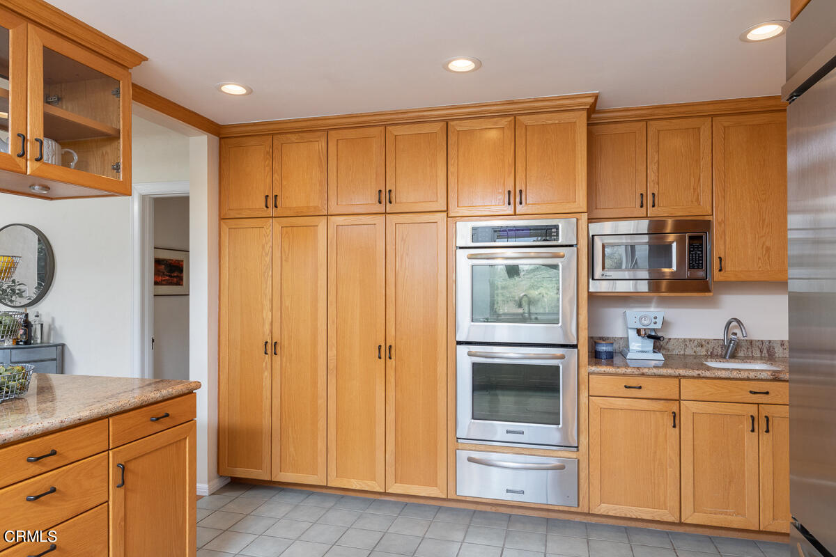1659 Kaweah Drive Pasadena, CA 91105 - Photo 22 of 46 a kitchen with stainless steel appliances granite countertop a refrigerator a sink dishwasher and wooden cabinets with wooden floor