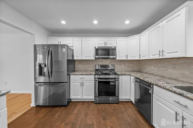 a kitchen with a refrigerator stove and wooden cabinets