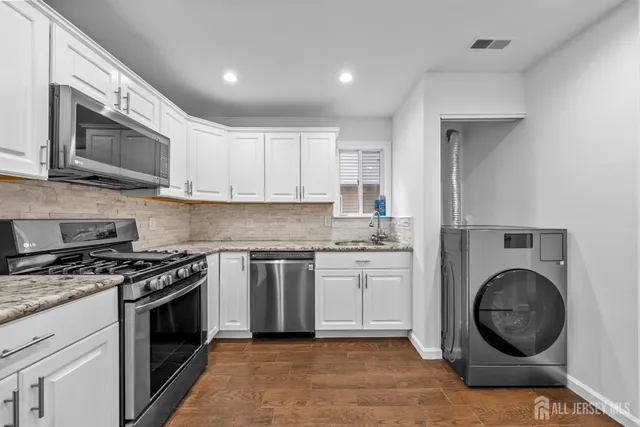 a kitchen with stainless steel appliances granite countertop a stove a microwave and a sink