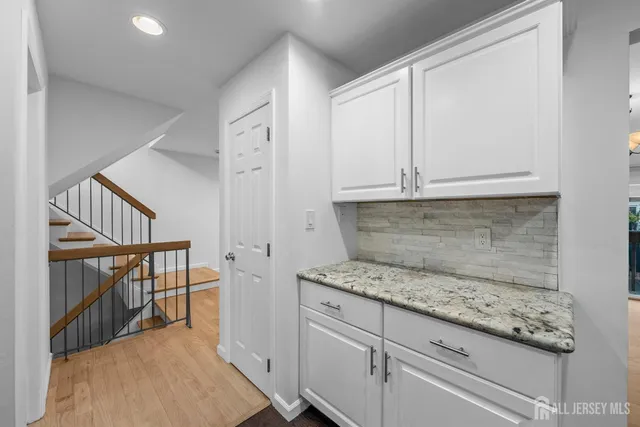 a kitchen with granite countertop white cabinets and white appliances