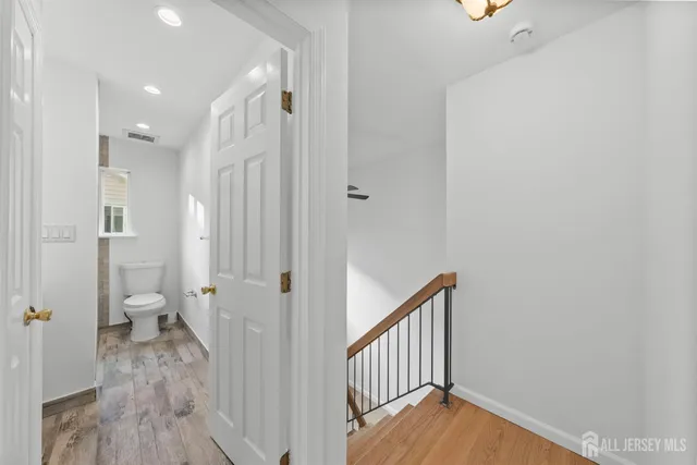 a view of a hallway with a livingroom and a bathroom with a sink