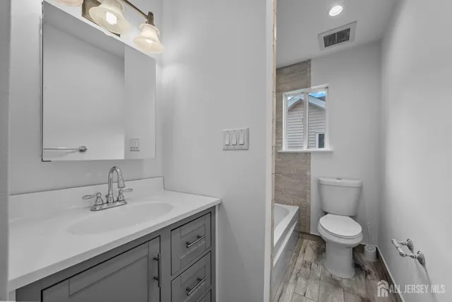 a bathroom with a sink a toilet and a mirror