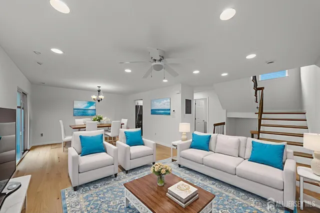 a living room with furniture and a ceiling fan