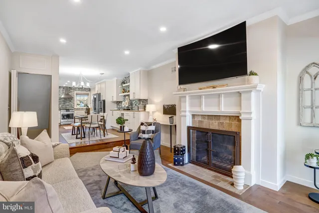 a living room with furniture a flat screen tv and a fireplace