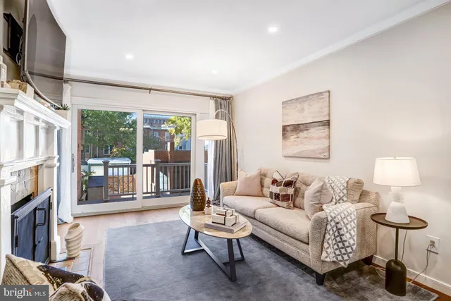 a living room with furniture a flat screen tv and a floor to ceiling window